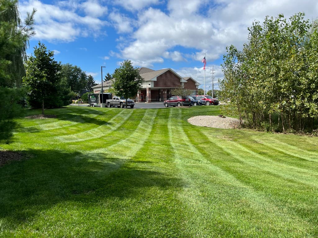 Master Gardner truck and trailer on a commercial property with freshly striped lawn